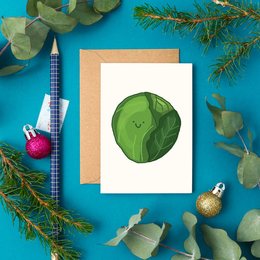 Cute mini Christmas greeting card with a festive hand-drawn Brussels sprout and smiley face