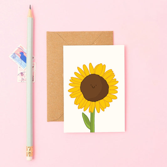 Hand-drawn sunflower with a happy face on a small greeting card. Great for thank you notes, summer displays, and cheering someone up.