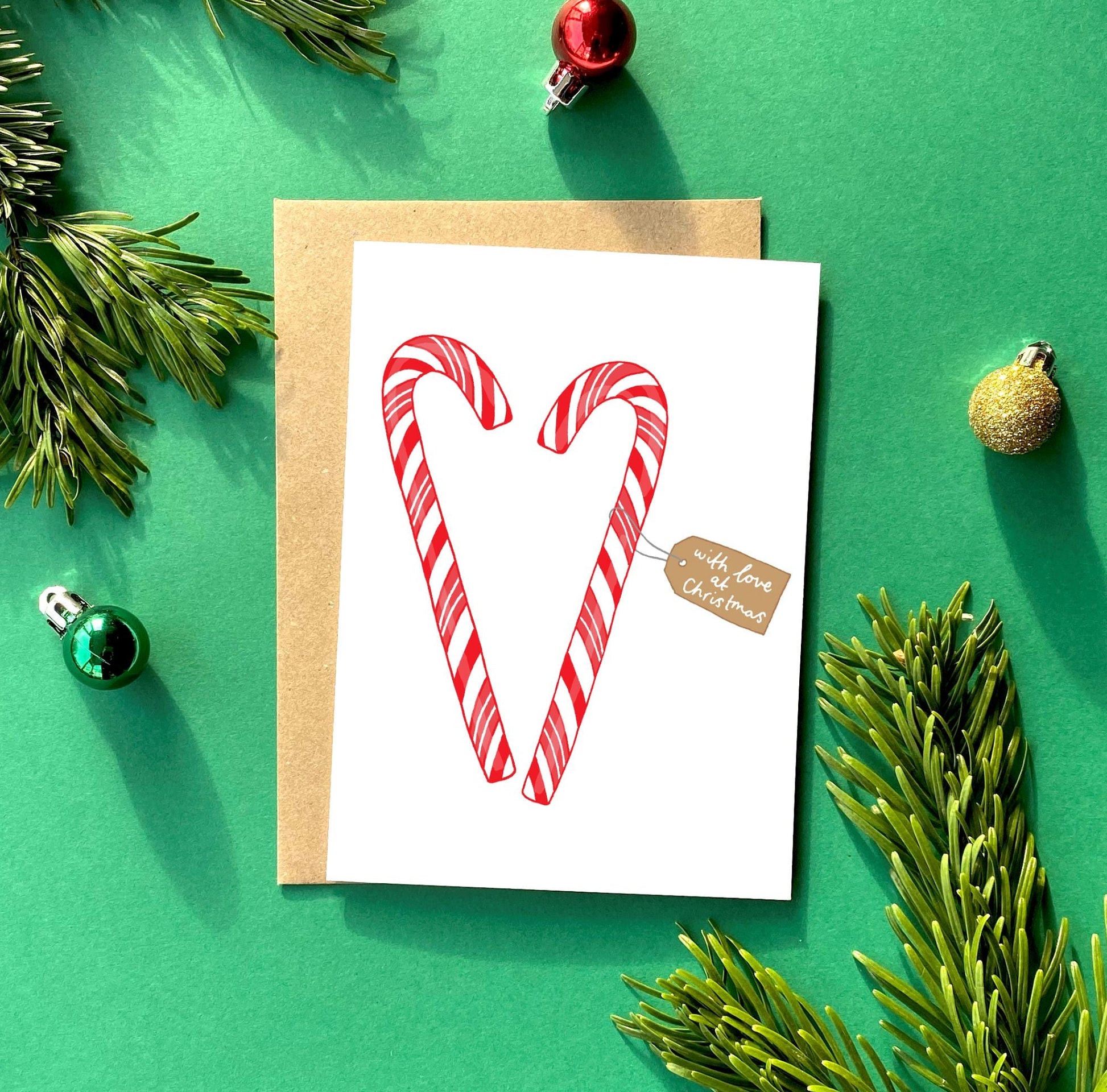 A Traditional Christmas Card Featuring Two Candy Canes in The Shape of a Heart