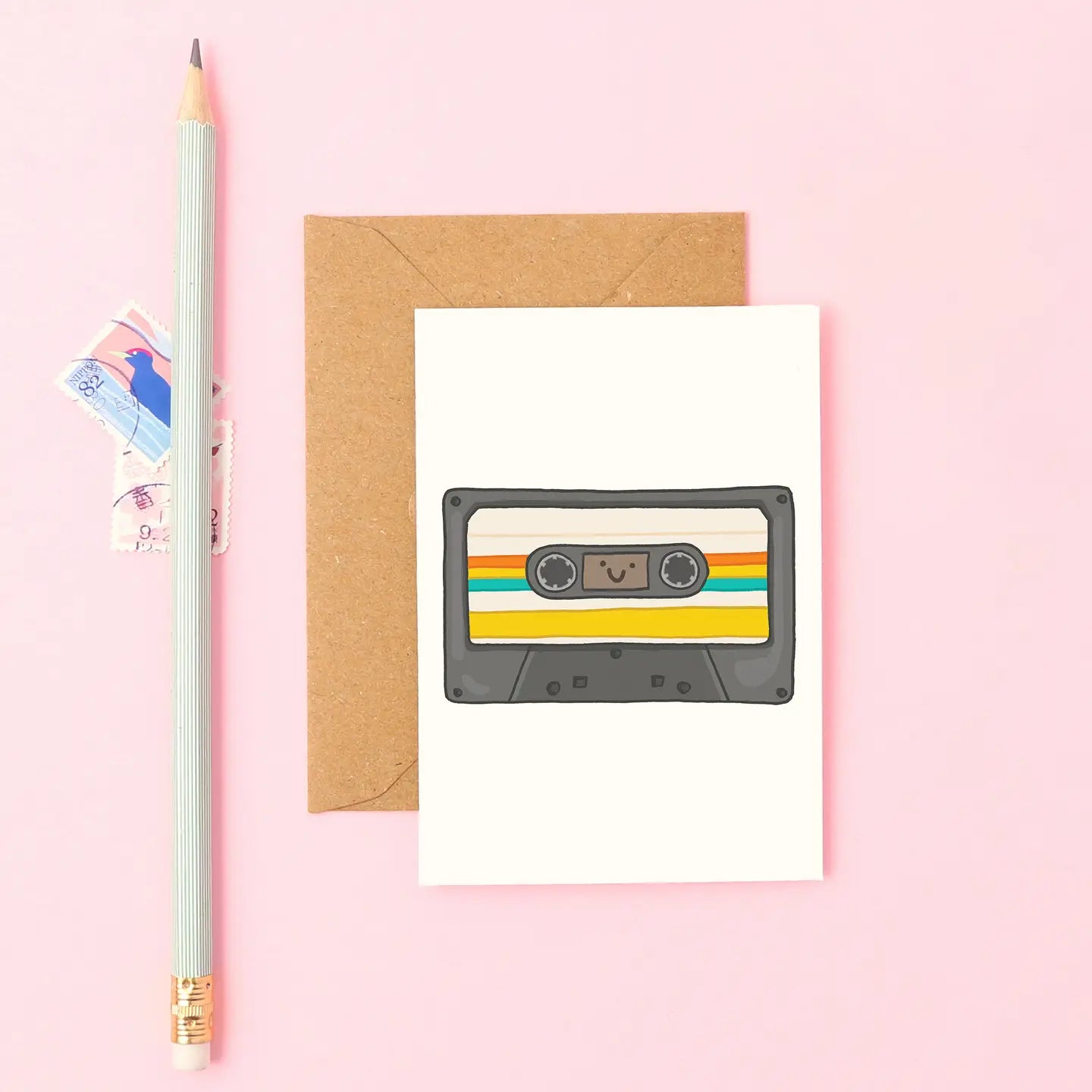 Mini retro card featuring hand drawn smiling cassette tape in black and rainbow