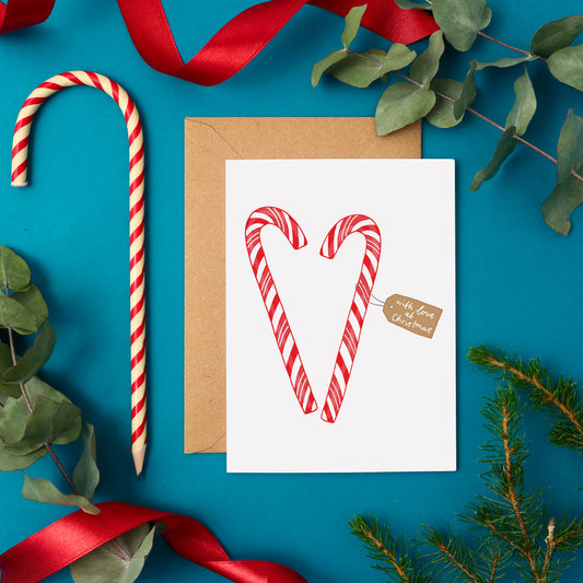 A Traditional Christmas Card Featuring Two Candy Canes in The Shape of a Heart