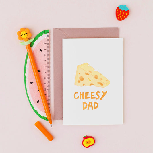 Cheesy Dad Father's Day card featuring a smiling wedge of cheese with gold foil lettering on a contemporary cream background.