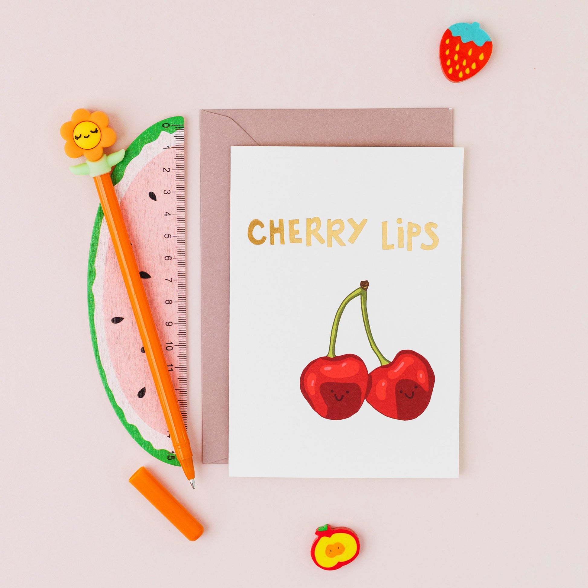 Cherry Lips greeting card featuring two smiling cherries with gold foil lettering on a contemporary cream background.