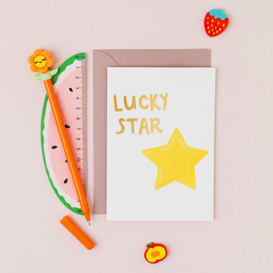 Lucky Star greeting card featuring a smiling yellow star with gold foil lettering on a contemporary white background.