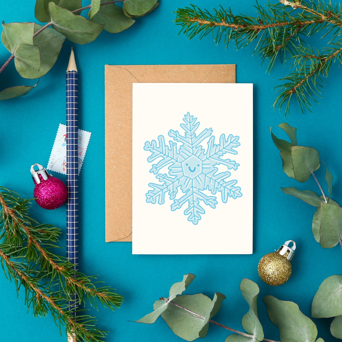 Cute mini card featuring a wintry blue hand-drawn snowflake with a friendly happy face.