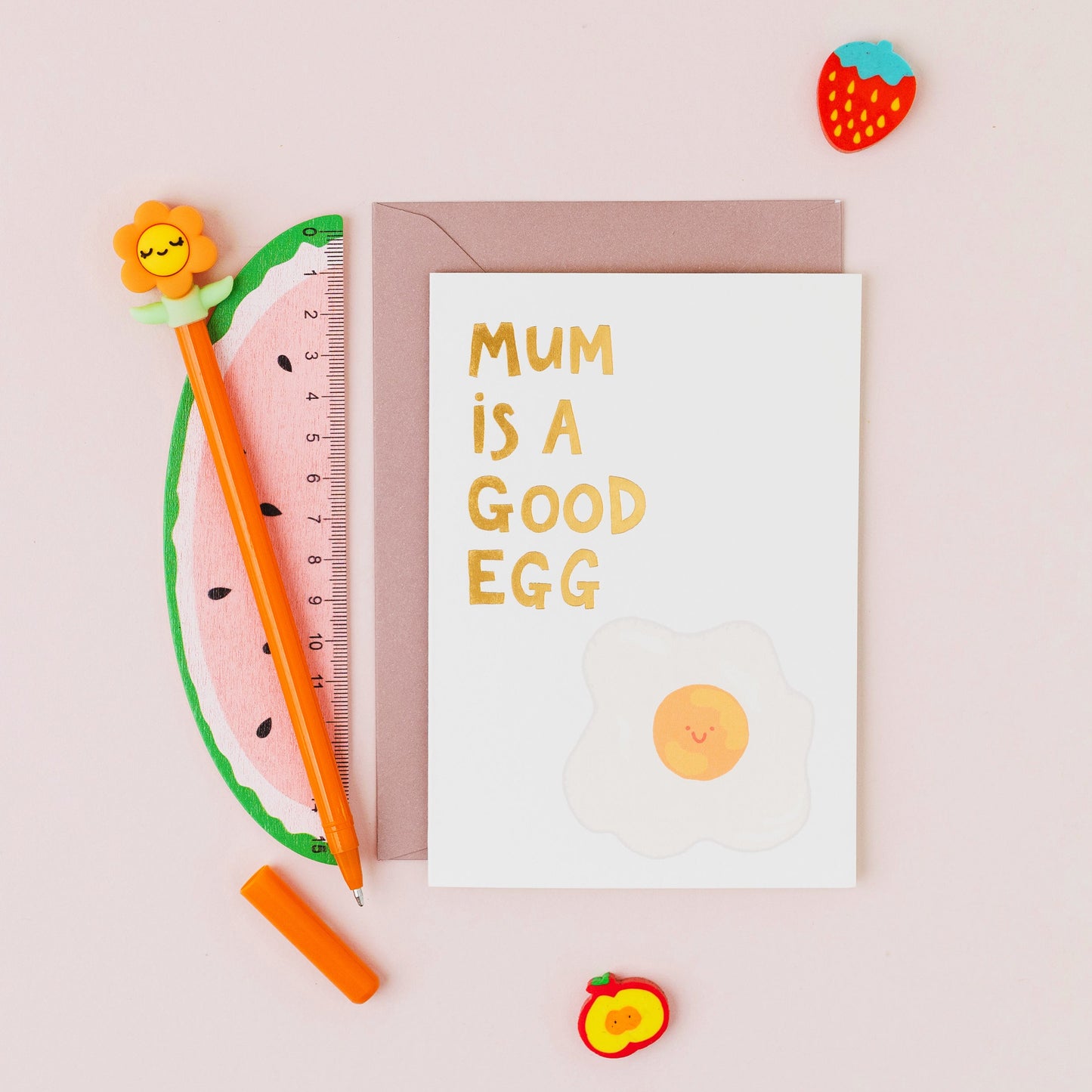 Mum Is A Good Egg greeting card featuring a smiling fried egg with gold foil lettering on a contemporary white background.

