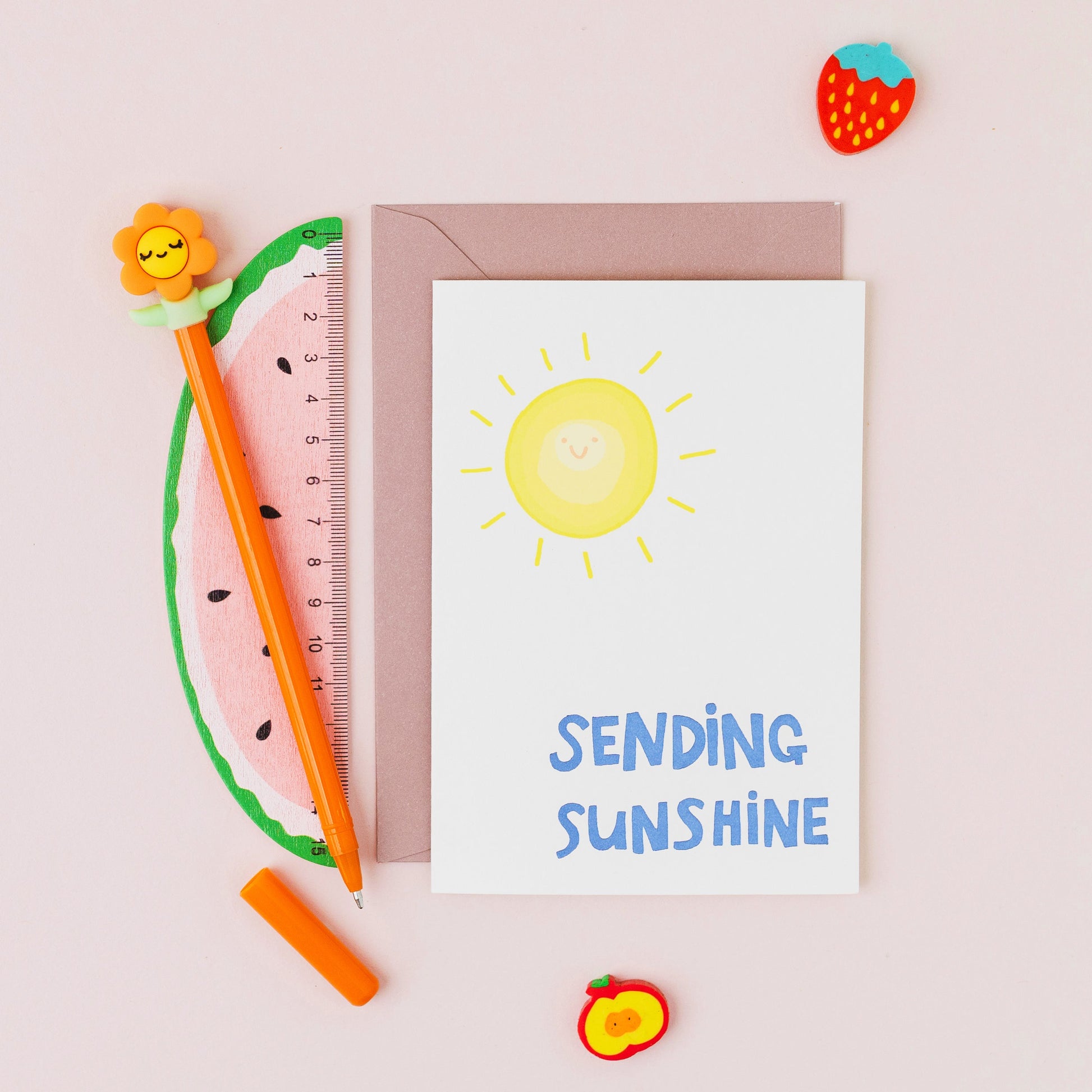 Sending Sunshine greeting card featuring a smiling sunshine with gold foil lettering on a white background.