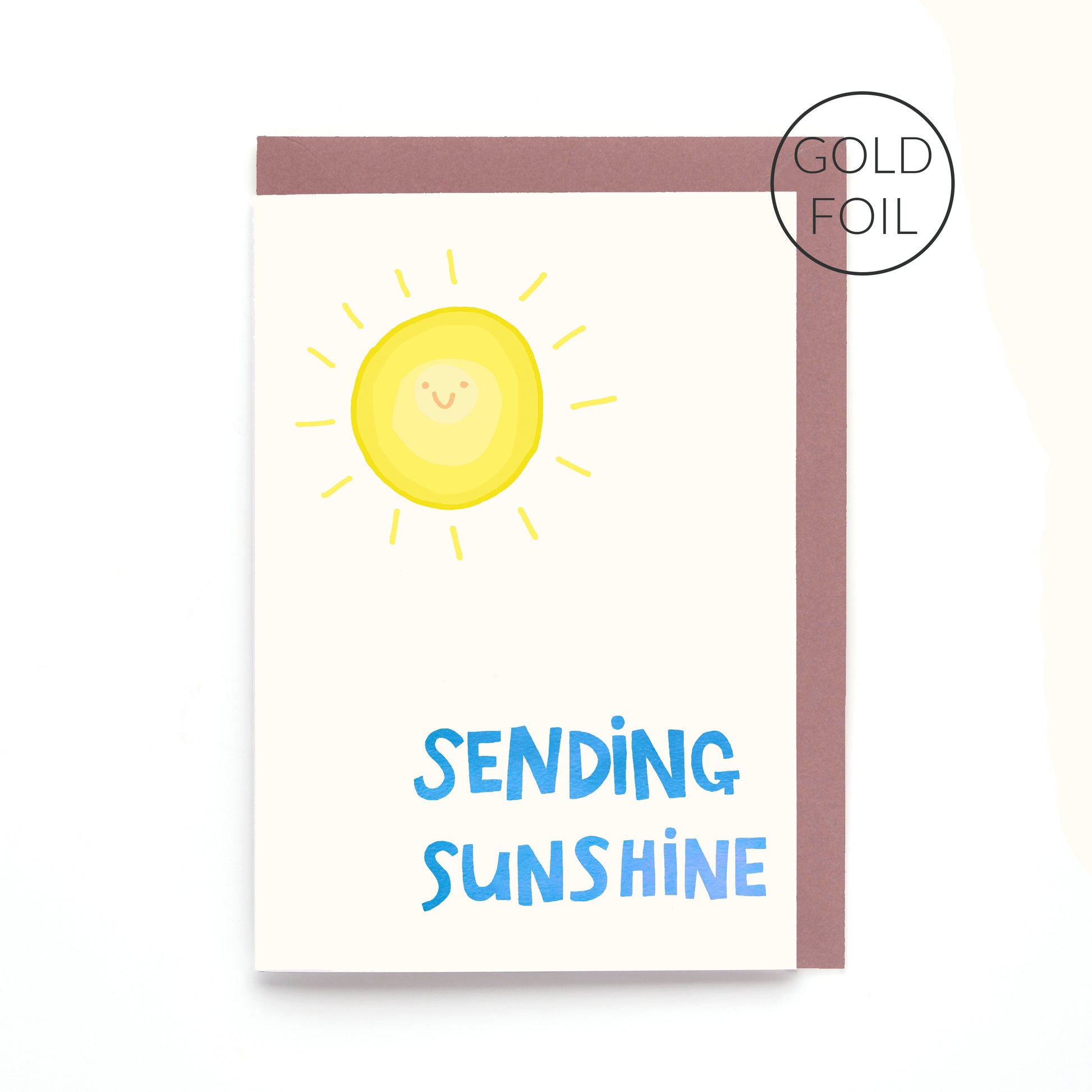 Sending Sunshine greeting card featuring a smiling sunshine with gold foil lettering on a white background.