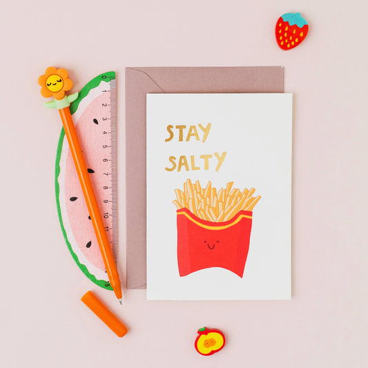 Funny chips greeting card reading "Stay Salty" with gold foil lettering on a white background.