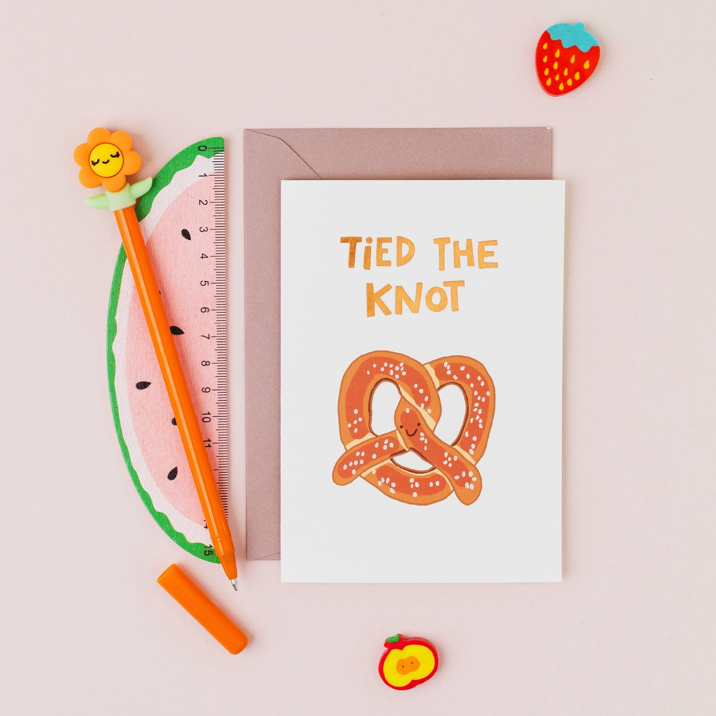 Hand drawn pretzel wedding greeting card with the words 'Tied The Knot' in gold foil on a white background.
